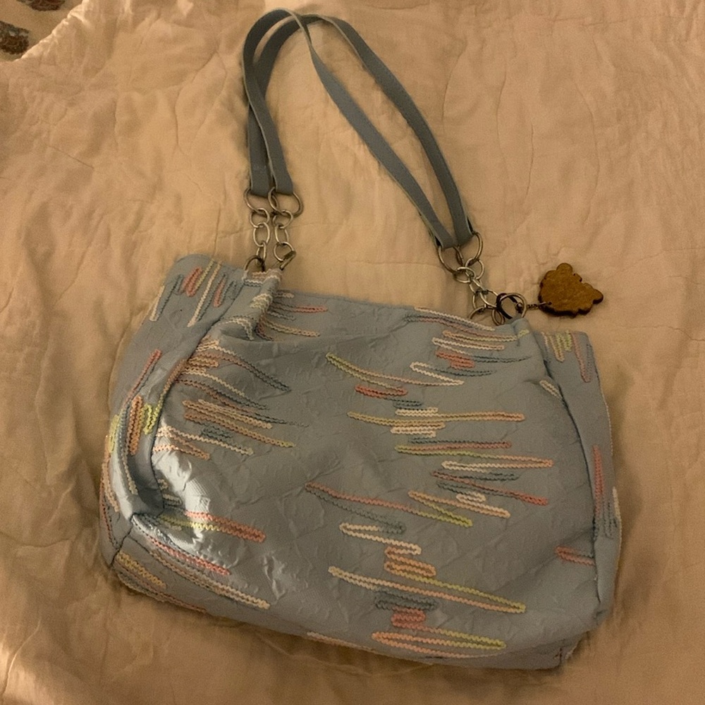 The light blue purse. Made with a neat fabric.